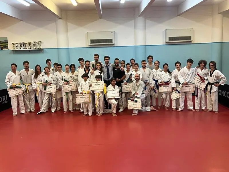Gruppo numeroso di atleti con i diplomi dopo il passaggio di cintura